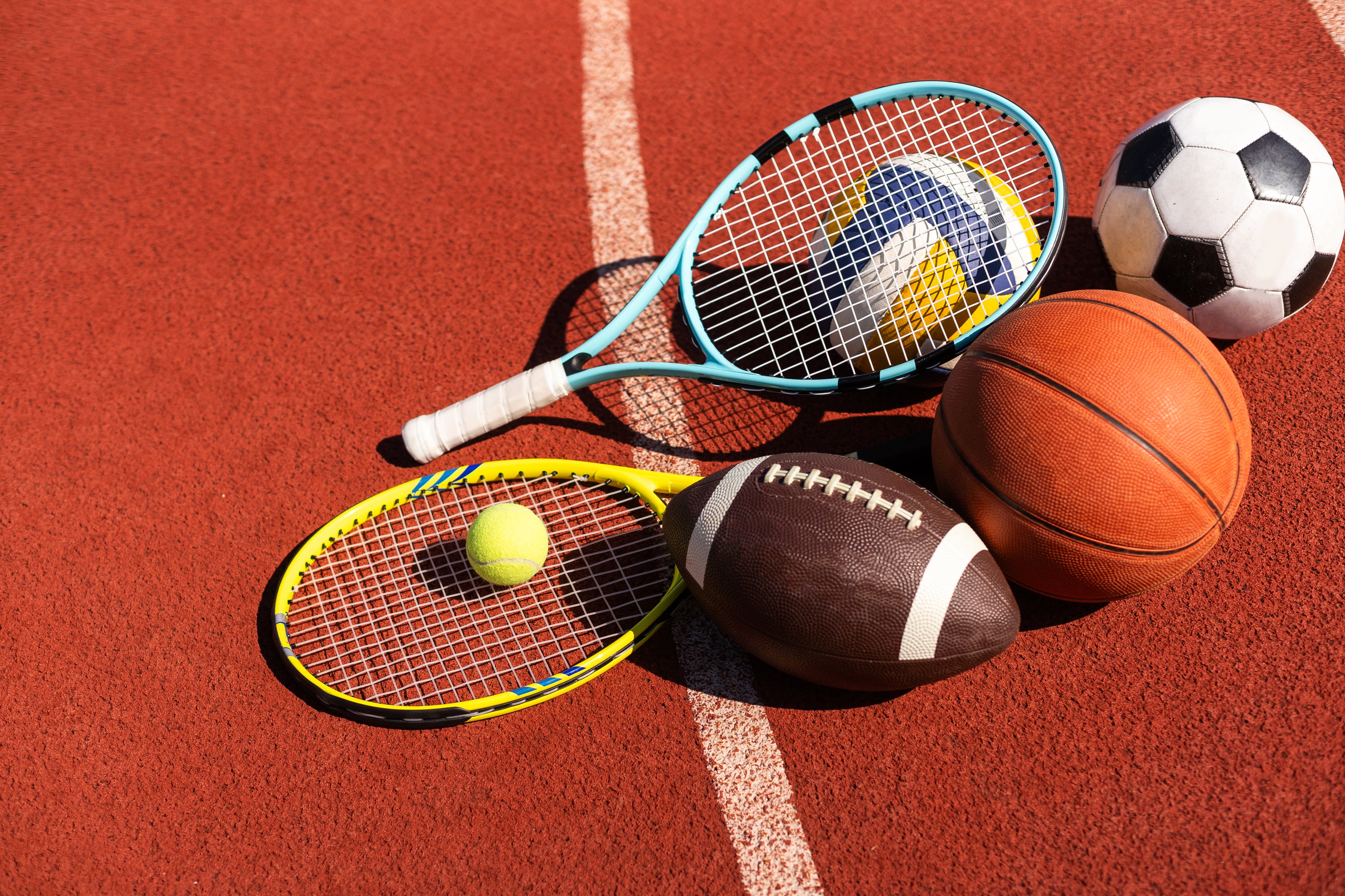 Raquettes et ballons de sport sur une piste d'athlétisme